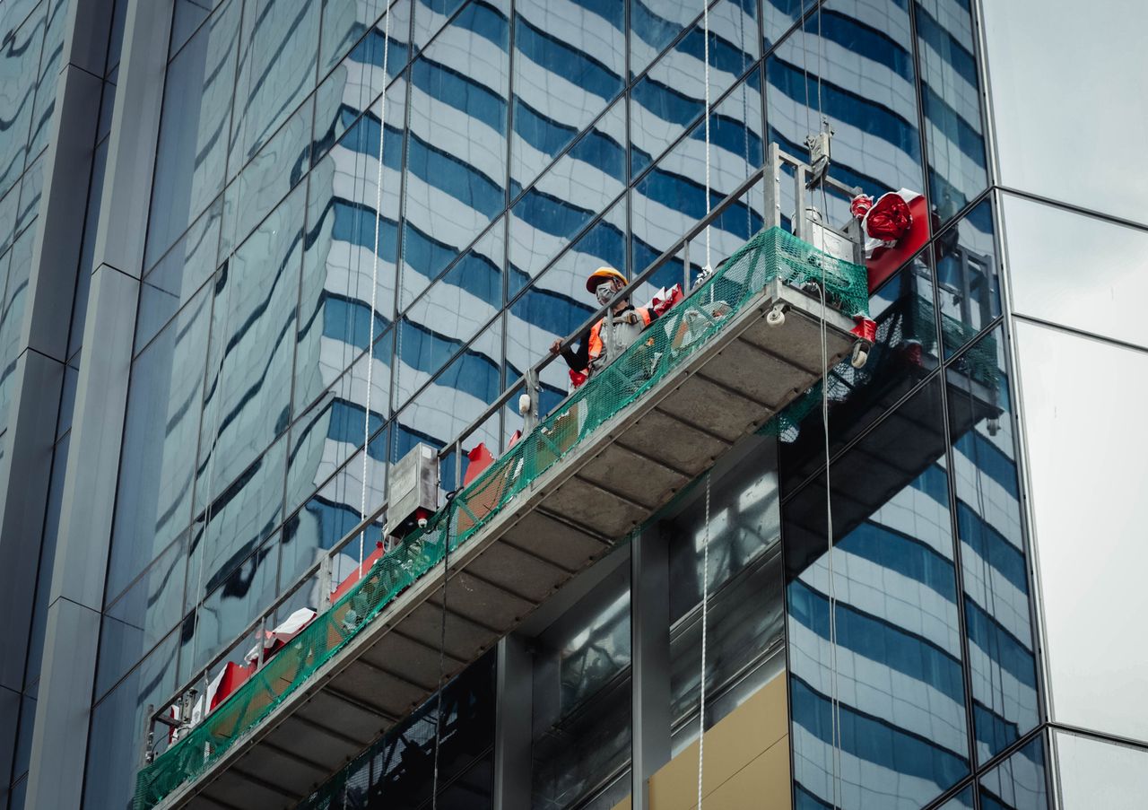 Un employé urbain nettoie les fenêtres d’un gratte-ciel à Ho Chi Minh City, Vietnam.